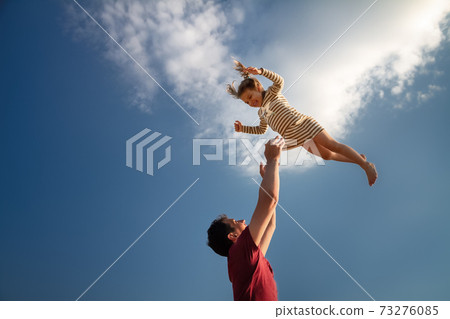 little girl 3 years flies out of daddy's hands against blue sky little girl 3 years flies out of daddy's hands against blue sky 73276085