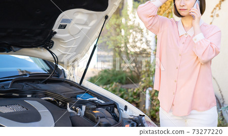 Young woman calling due to car trouble 73277220