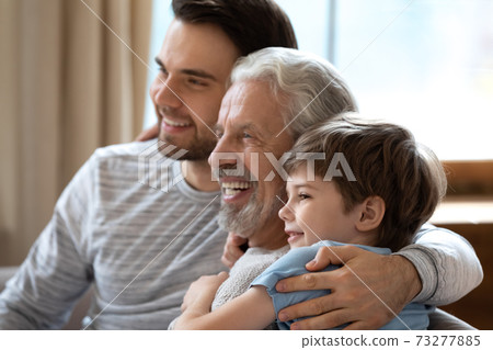 Happy three generations of men look in distance dreaming Happy three generations of men look in distance dreaming 73277885