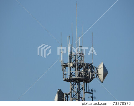 Radio tower towering in the blue sky 73278573