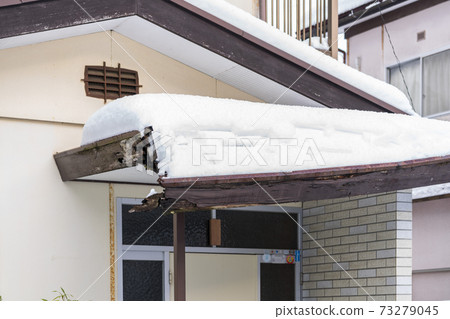 The roof of the entrance broken by the weight of snow 73279045