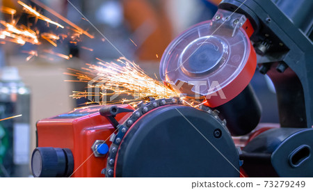 Automatic saw chain sharpening machine during work at workshop - close up Automatic saw chain sharpening machine during work at workshop - close up 73279249