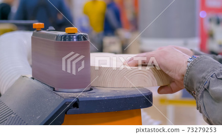 Man carpenter using belt sander machine, polishing wood product: close up Man carpenter using belt sander machine, polishing wood product: close up 73279253