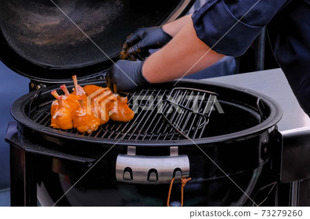 Chef preparing chicken legs with spices at street food festival Chef preparing chicken legs with spices at street food festival 73279260