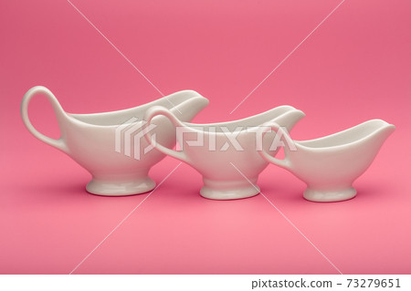 Three sauce boats of all sizes on pink background 73279651