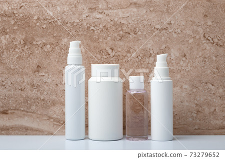 Set of unbranded beauty products for skincare on white table against marble background 73279652