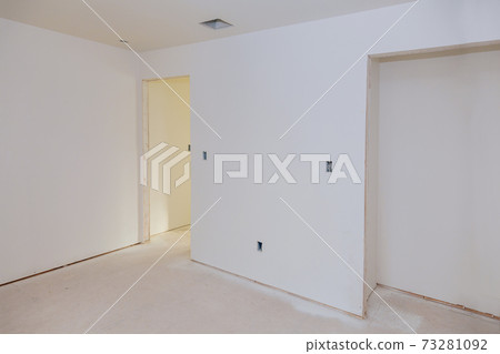 Finishing putty in the room walls plasterboards with room under construction 73281092