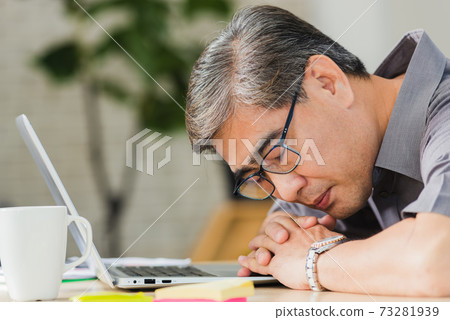 businessman tired overworked he sleeping over a laptop computer 73281939