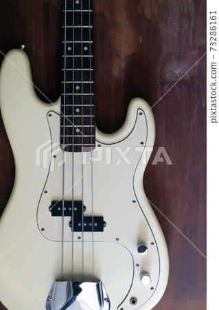 white electric bass guitar on wood background  73286161