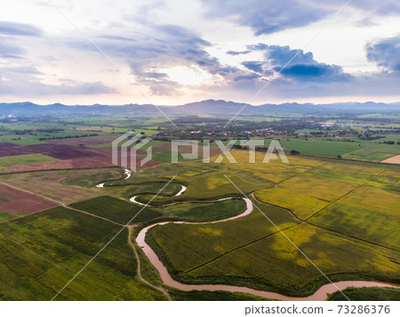 Scenic landscape aerial view of field river and basin against a natural mountain, Drone shot tropical landscape with noise and grain processed 73286376