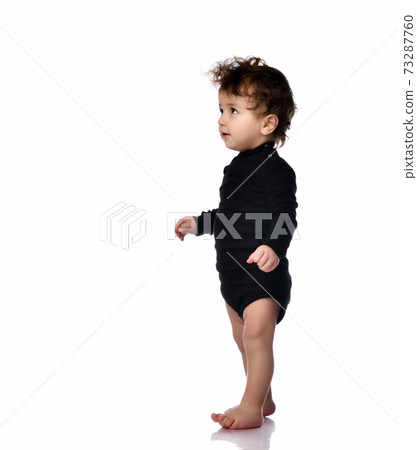 Baby walking taking first step portrait isolated 73287760