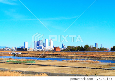 Scenery of skyscrapers in front of Nagoya Station as seen from the riverbed of the Shonai River in Nagoya City 73289173