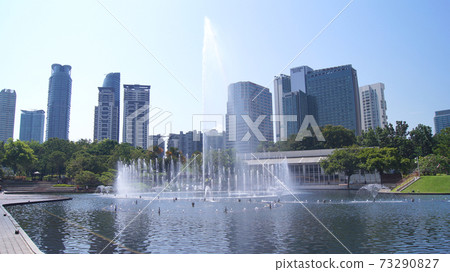 KUALA LUMPUR, MALAYSIA - 13 APRIL 2015: A body of water and a fountain with a city in the background 73290827