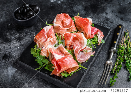 Italian parma prosciutto crudo dried ham on a marble board. Black background. Top view Italian parma prosciutto crudo dried ham on a marble board. Black background. Top view 73291857
