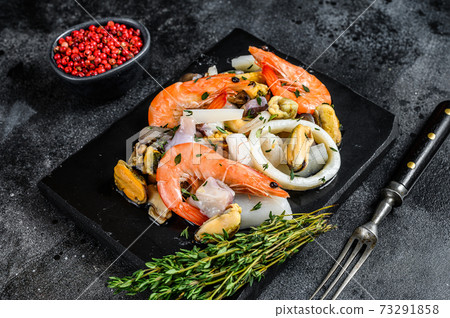 Fresh mix seafood cocktail with shrimps, prawns, mussels, squids and octopus. Black background. Top view 73291858