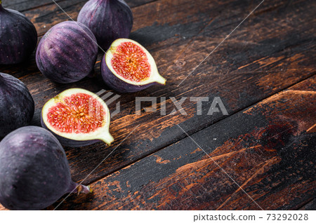 Portion of fresh Figs on vintage wooden table. Dark wooden background. Top view. Copy space Portion of fresh Figs on vintage wooden table. Dark wooden background. Top view. Copy space 73292028