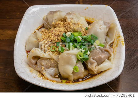 The close up of Taiwanese traditional steamed spicy stinky tofu wontons cuisine on old wooden table at food night market restaurant in Taipei, Taiwan. 73292401