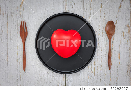heart in black round dish with spoon and fork heart in black round dish with spoon and fork 73292937