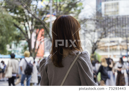 Back view of a woman standing in front of Shibuya station 73293443