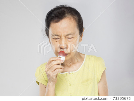 old asian woman feel headache have nosebleed 73295675