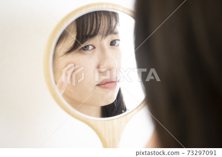 一個女人看著鏡子困擾著 73297091