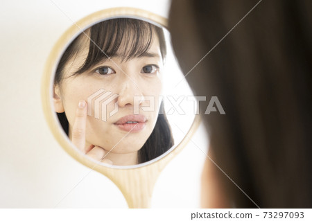 一個女人看著鏡子困擾著 73297093