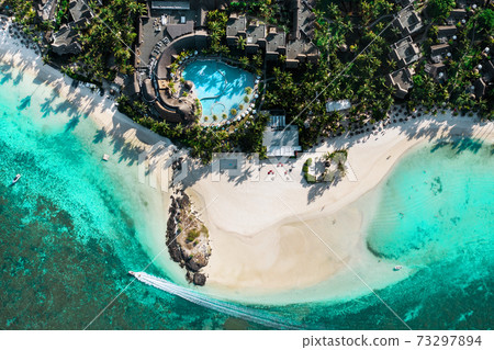 View from the height of the east coast of the island of Mauritius. Flying over the turquoise lagoon of the island of Mauritius in the area of Bel Mare. 73297894