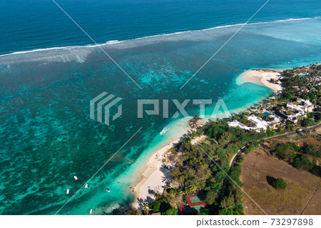 View from the height of the east coast of the island of Mauritius. Flying over the turquoise lagoon of the island of Mauritius in the area of Bel Mare. View from the height of the east coast of the island of Mauritius. Flying over the turquoise lagoon of the island of Mauritius in the area of Bel Mare. 73297898