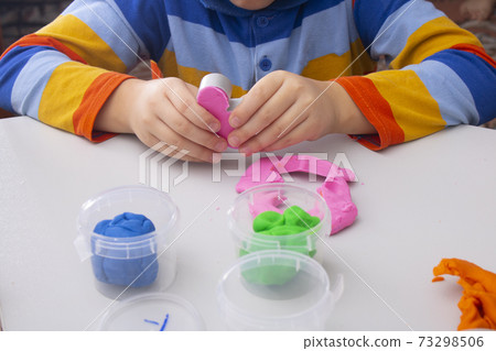 Child hands playing with colorful clay. Boy molding modeling clay. Homemade clay. 73298506