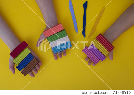 Preschoolers with colorful clay. Toddler playing and creating toys from play dough. Preschoolers with colorful clay. Toddler playing and creating toys from play dough. 73298510