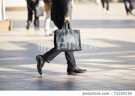 A businessman walking with a bag A businessman walking with a bag 73298536