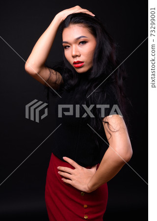 Young beautiful Asian transgender businesswoman against black background 73299001