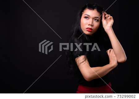 Young beautiful Asian transgender businesswoman against black background 73299002