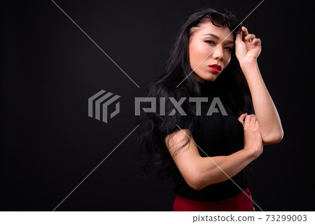 Young beautiful Asian transgender businesswoman against black background 73299003