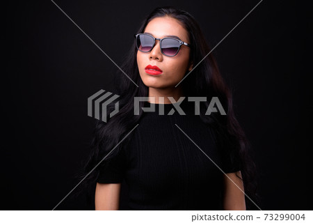 Young beautiful Asian transgender businesswoman against black background 73299004
