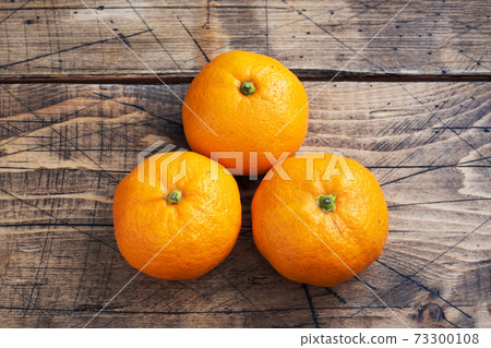Oranges tangerines or mandarins clementines, citrus fruits on rustic wooden background, copy space. Oranges tangerines or mandarins clementines, citrus fruits on rustic wooden background, copy space. 73300108