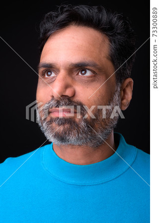 Portrait of mature bearded Indian man with curly hair 73300889