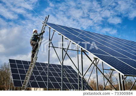 Male worker climbing the ladder to check solar panel. Male worker climbing the ladder to check solar panel. 73300984