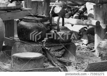 Metal kettle. Old-fashioned boiling water uses firewood to make a fire. Black and White. 73301271