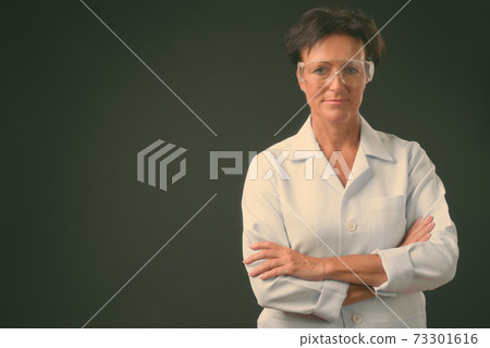 Mature beautiful woman doctor with short hair against black background Mature beautiful woman doctor with short hair against black background 73301616