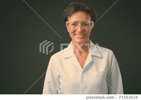 Mature beautiful woman doctor with short hair against black background Mature beautiful woman doctor with short hair against black background 73301619