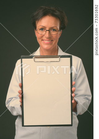 Mature beautiful woman doctor with short hair against black background Mature beautiful woman doctor with short hair against black background 73301692