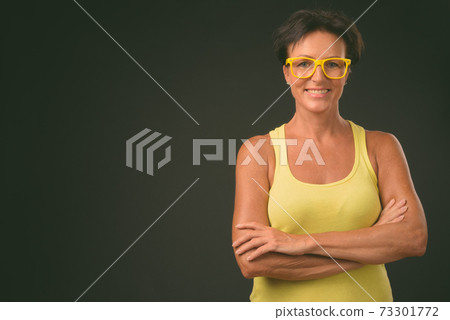 Mature beautiful woman with short hair against black background 73301772