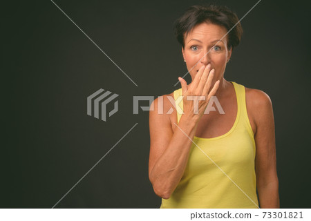 Mature beautiful woman with short hair against black background Mature beautiful woman with short hair against black background 73301821