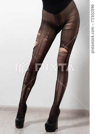 Beautiful slender young woman in torn tights Beautiful slender young woman in torn tights 73302896
