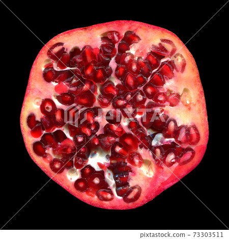 Half cut red colored juicy ripe pomegranate isolated black background 73303511