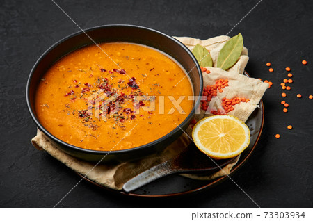 Ezogelin Soup in black bowl on dark slate table top. Turkish cuisine traditional dish  73303934