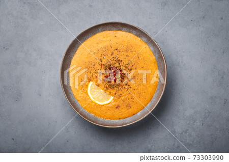 Ezogelin Soup in gray bowl on concrete table top. Turkish cuisine traditional dish Ezogelin Soup in gray bowl on concrete table top. Turkish cuisine traditional dish 73303990