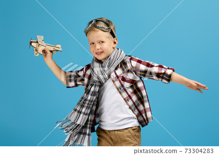 child boy in retro glasses playing with wooden toy airplane child boy in retro glasses playing with wooden toy airplane 73304283