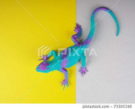 toy iguana lizard on a gray and yellow background, concept photo, space for text toy iguana lizard on a gray and yellow background, concept photo, space for text 73305190